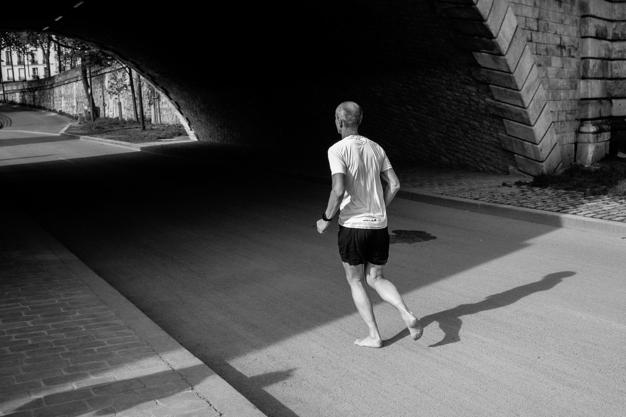 Man Runs Barefoot Under Bridge